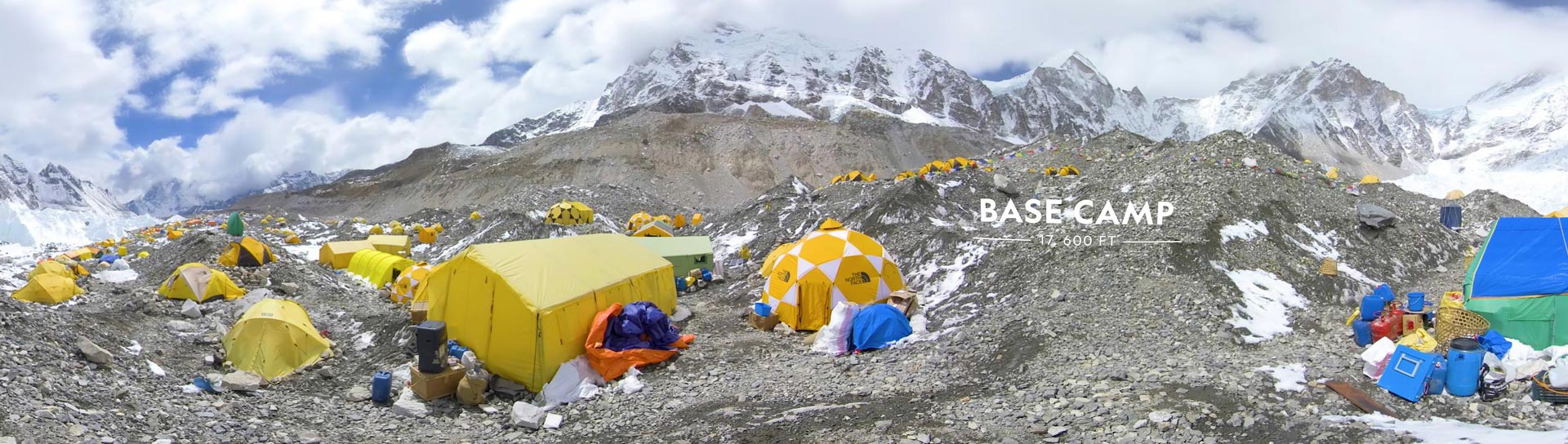 Panoramic view of Base Camp at Mount Everest with tents scattered about.