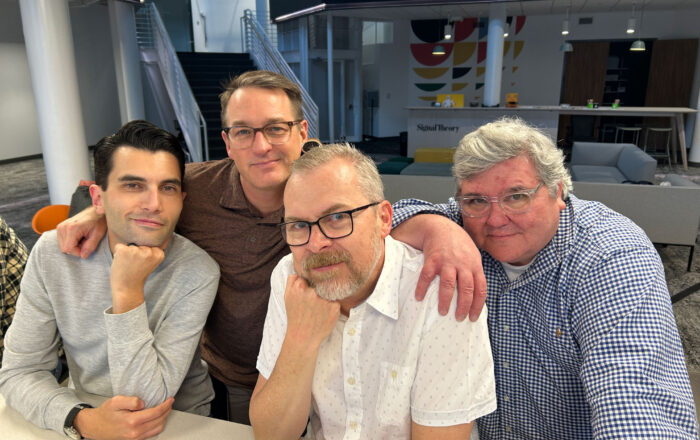 Jon Kowing with friends at his in-office retirement party posing seriously for the camera